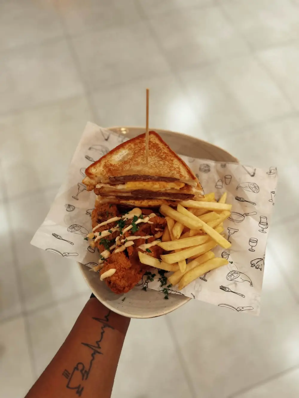 Stacked toasted sandwich with egg and patty, crumbed chicken and chips